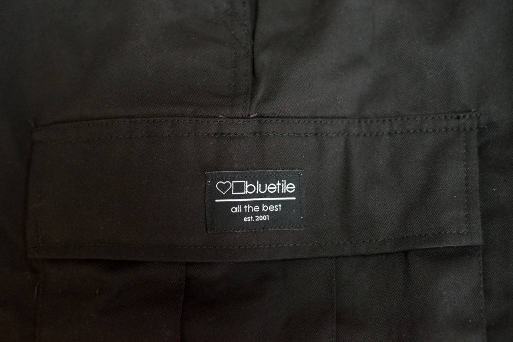 A close up of BLUETILE SURPLUS CARGO PANT BLACK jacket with utility pockets from Bluetile Skateboards.