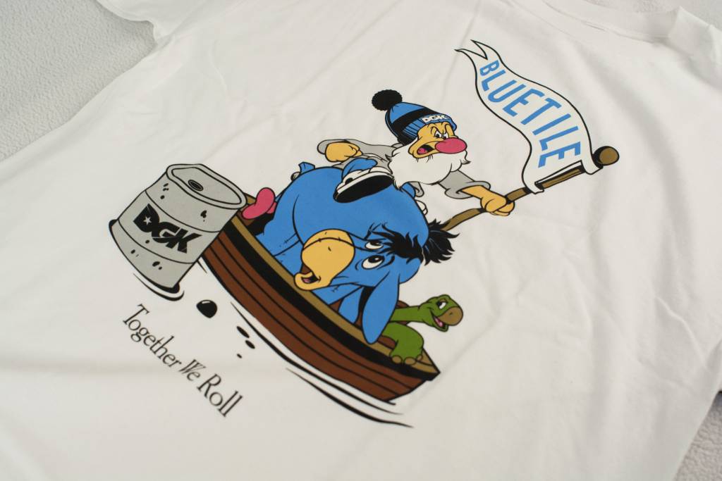 A BLUETILE X DGK TOGETHER WE ROLL t-shirt with a cartoon character in a boat, by Bluetile Skateboards.