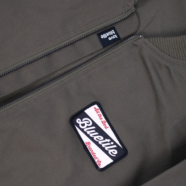 A close up of a Bluetile Skateboards BLUETILE CRAFT BOMBER JACKET with a label on it.