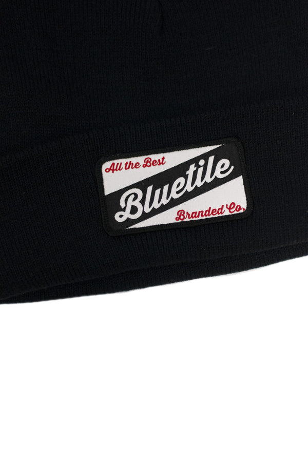 A black BLUETILE CRAFT PATCH BEANIE NAVY with a Bluetile Skateboards patch on it.