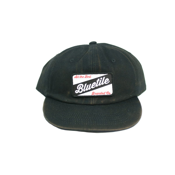 A BLUETILE CRAFT PATCH HAT FADED BLACK with the word bluebell and a bluetile patch from Bluetile Skateboards.