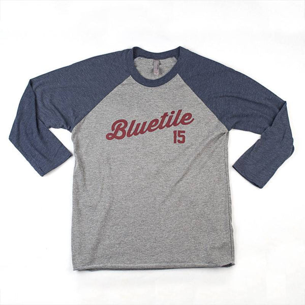 A Bluetile Skateboards t-shirt with the word "BLUETILE 15 YEARS OF REFLECTION RAGLAN" on it.