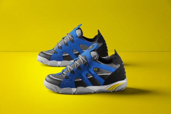A pair of ES SCHEME ROYAL / BLACK / WHITE sneakers on a yellow background with a breathable mesh upper and lightweight synthetic nubuck materials.