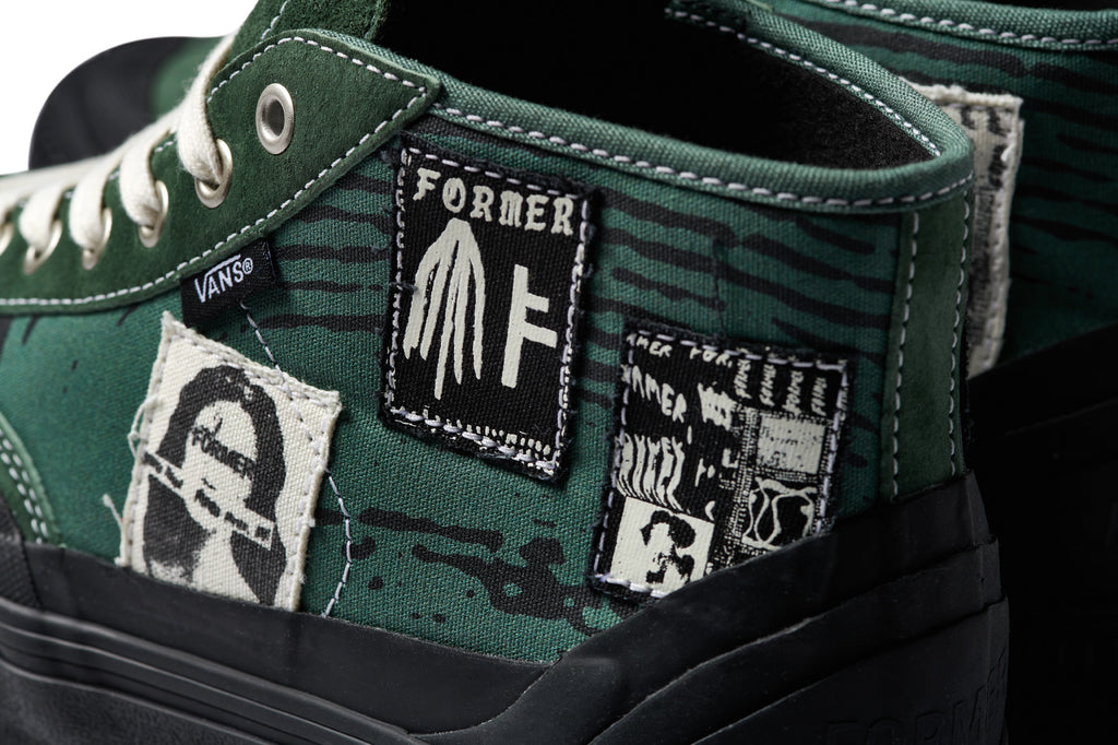 A pair of VANS X FORMER DESTRUCT MID MTE GREEN shoes with patches on them.