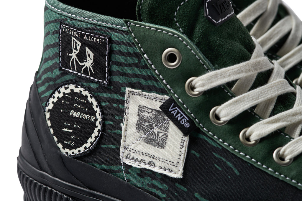 A pair of VANS X FORMER DESTRUCT MID MTE GREEN shoes with white laces.