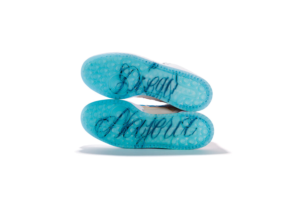 A pair of blue ADIDAS DIEGO FORUM 84 MID ADV CHALK WHITE / CLOUD WHITE shoes with the words dream happy written on them.