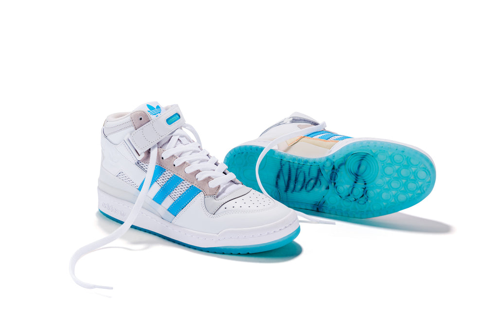 The ADIDAS DIEGO FORUM 84 MID ADV CHALK WHITE / CLOUD WHITE sneakers are showcased on a pristine white surface.