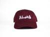 A BLUETILE CURSIVE DAD HAT MAROON with the word 'bluets' embroidered on it in CURSIVE. (Brand Name: Bluetile Skateboards)