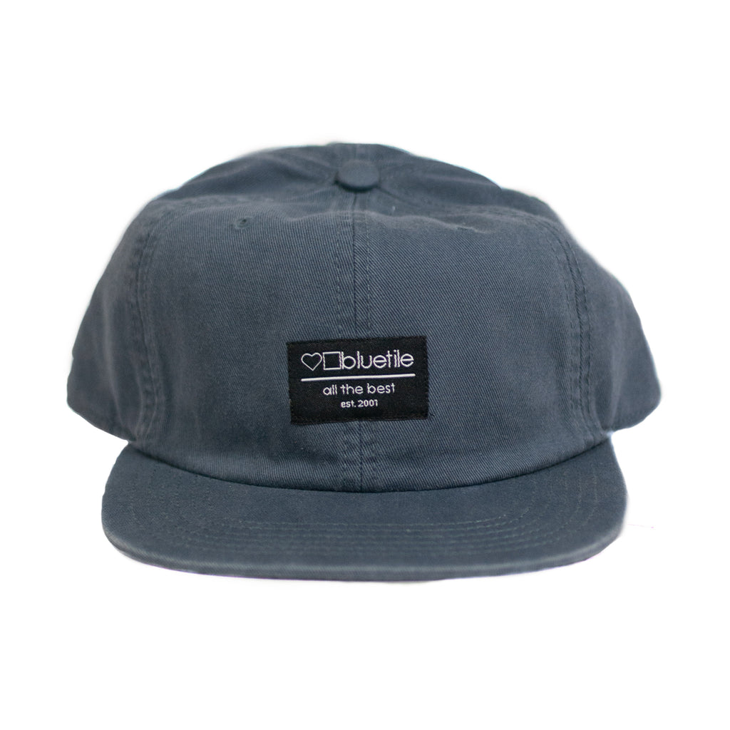 A BLUETILE SUPPLY PATCH HAT PETROL BLUE with a Bluetile Skateboards logo patch on it.