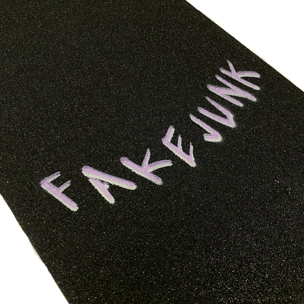 A close-up of FAKE JUNK GRIPTAPE MOREGRIP FORMULA by FAKE JUNK, featuring "FAKE JUNK" in purple block letters on black griptape.