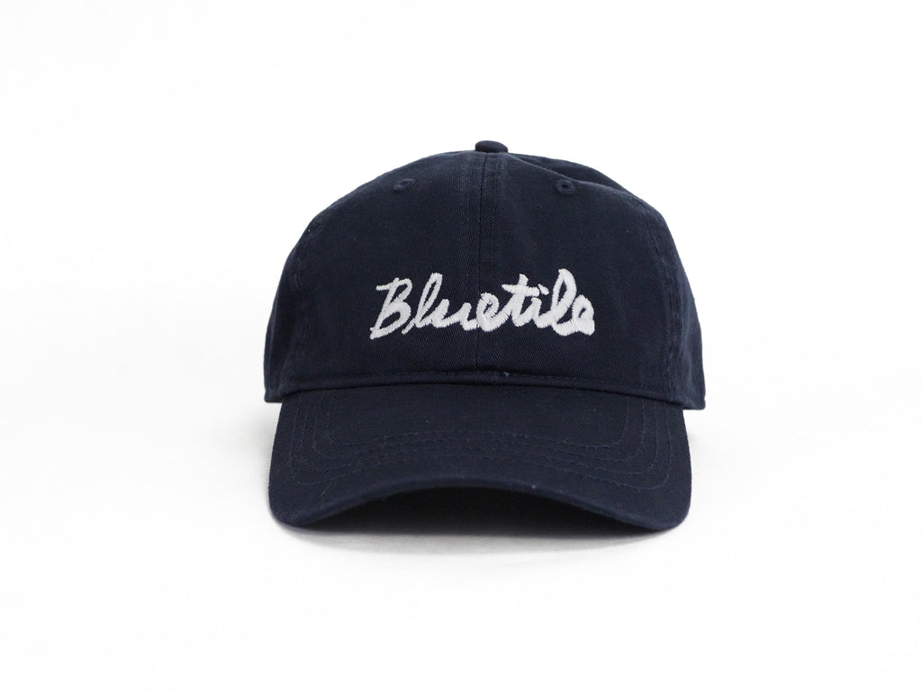 A BLUETILE CURSIVE DAD HAT NAVY with the word 'blues' embroidered in cursive by Bluetile Skateboards.