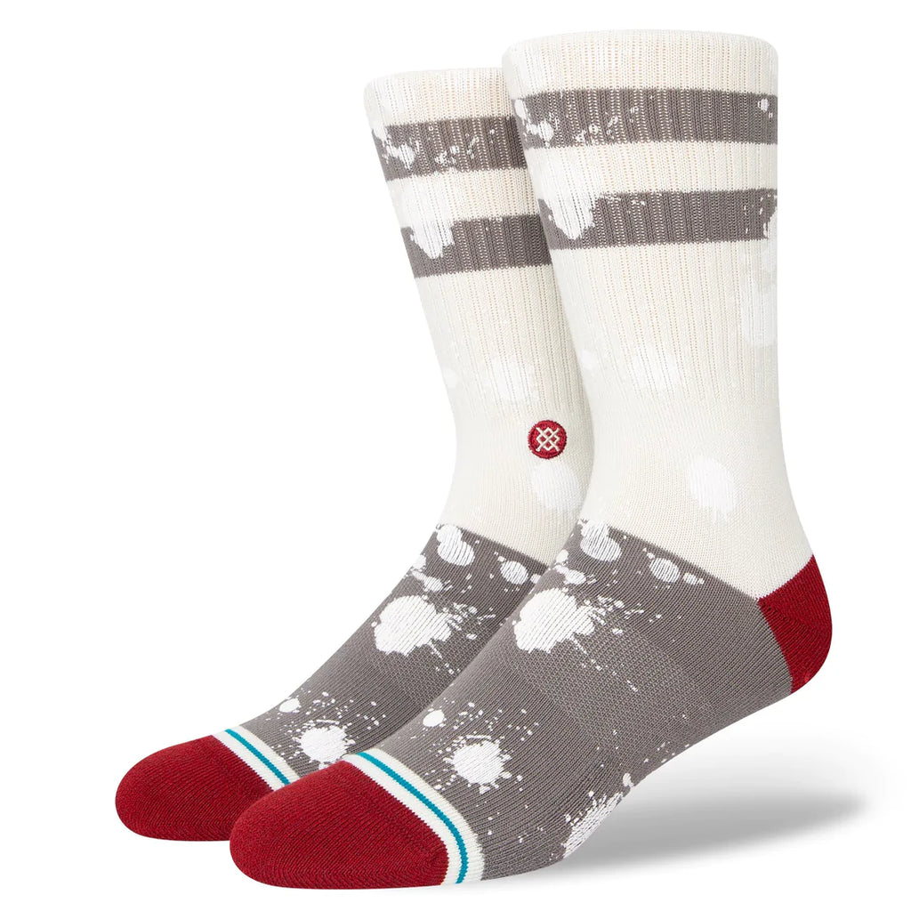 A pair of STANCE ISHOD CUSTOM OFF WHITE LARGE socks with white and red paint splattered on them.