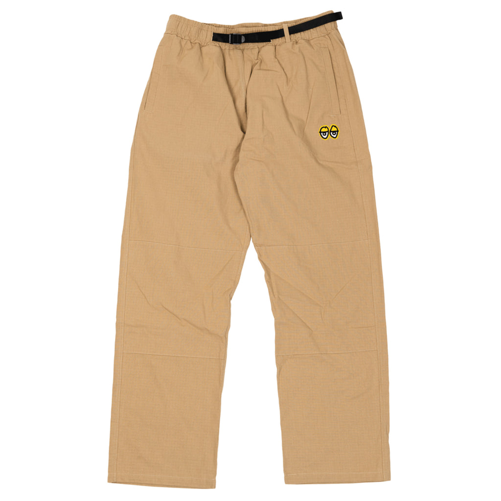 A DELUXE KROOKED EYES DOUBLE KNEE PANTS KHAKI / YELLOW with a yellow smiley face on it.