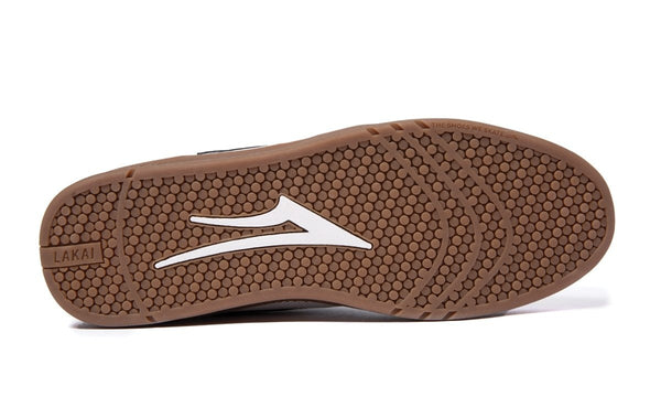 A pair of LAKAI BRIGHTON WHITE/GUM SUEDE flip flops with a white logo.