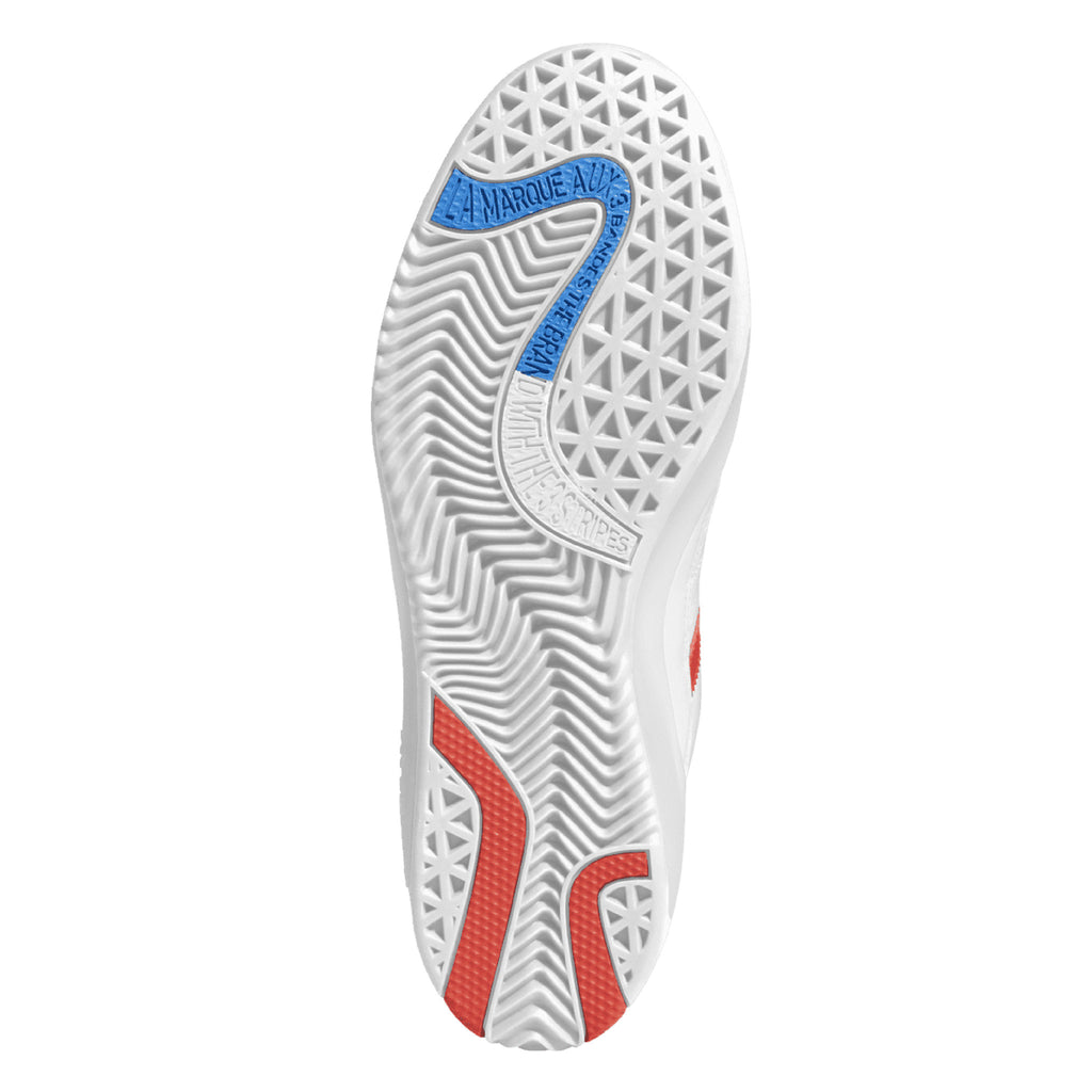 The sole of a white shoe with red and blue accents