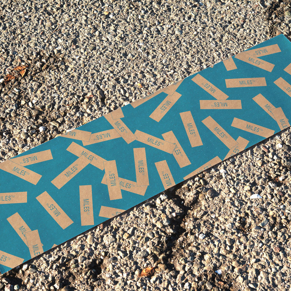 A MILES skateboard that has been placed on the ground.