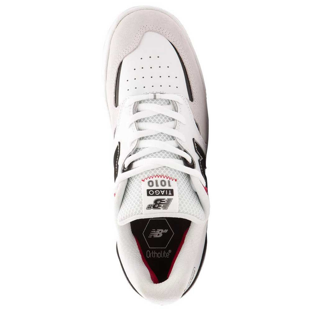 The NB NUMERIC TIAGO 1010 WHITE / BLACK shoe from NB NUMERIC is a stylish white and black shoe with vibrant red accents.