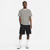 A man in a striped shirt and NIKE SB CARGO SHORT KNEE LENGTH BLACK shorts from Nike.