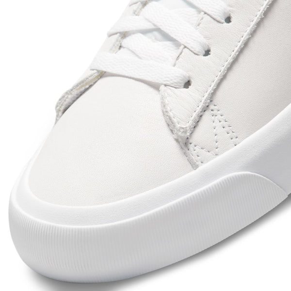 Close-up of a white nike NIKE SB BLAZER LOW PRO GT ISO WHITE / LIGHT COGNAC sneaker showing the laces, stitching details, and the textured toe cap.