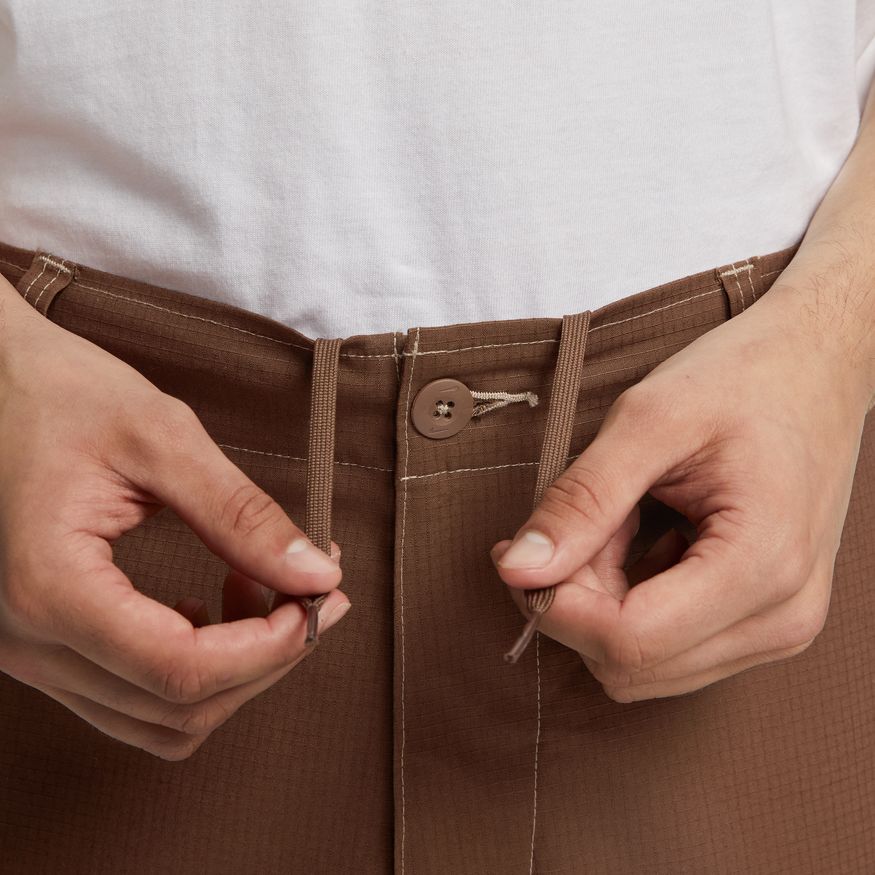 a person holding a Nike SB Kearny Skate Cargo Pant Cacao in their hands.