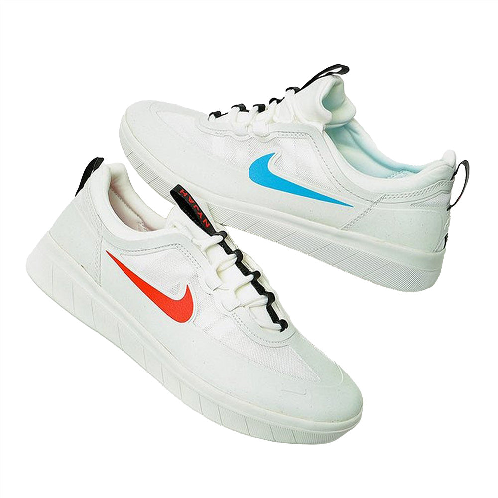 A pair of NIKE SB NYJAH FREE II SUMMIT WHITE/BLUE HERO sneakers with thick soles—one with a blue swoosh, the other with red—ideal for skateboarding, seen on Columbia SC streets.