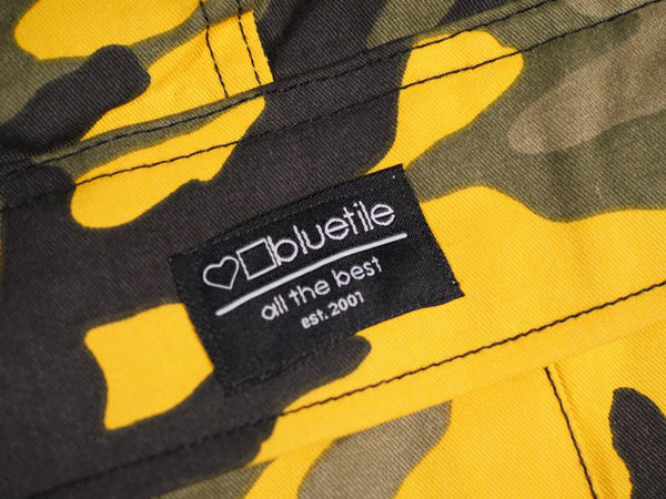 The label on a BLUETILE SURPLUS CARGO PANT STINGER YELLOW by Bluetile Skateboards camouflage jacket.