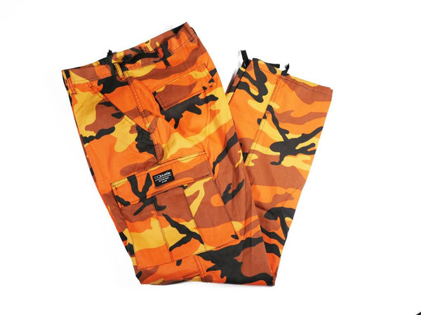 A pair of Bluetile Skateboards BLUETILE SURPLUS CARGO PANT ORANGE CAMO pants on a white background.