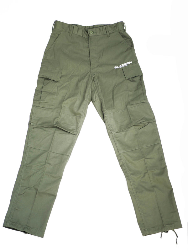 The SLAMMIN CARGO PANT OLIVE, featuring adjustable waist tabs, a reinforced seat and knees, and multi-use utility pockets, is displayed flat against a white background. The right pocket area is adorned with the text "SLAMMIN" in white letters.