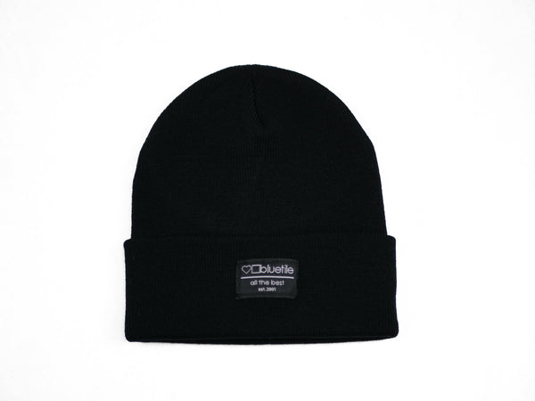 A BLUETILE SURPLUS BEANIE BLACK with a Bluetile Skateboards label on it.