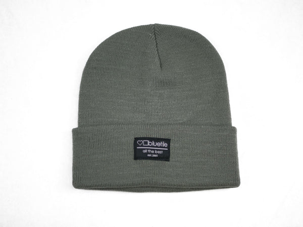 A BLUETILE SURPLUS BEANIE GREY with a black label on it.