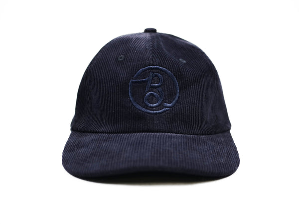 A Bluetile Skateboards navy corded hat with the letter b on it, featuring a Bluetile Supply Co corduroy strap back.