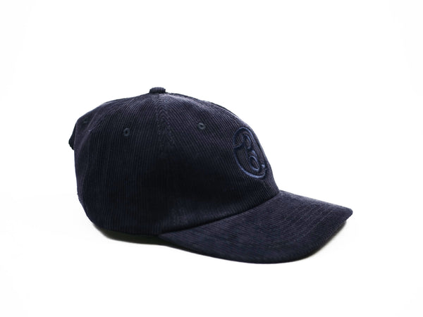 A black BLUETILE SUPPLY CO CORDUROY STRAP BACK NAVY baseball cap with a Bluetile Skateboards logo on it.