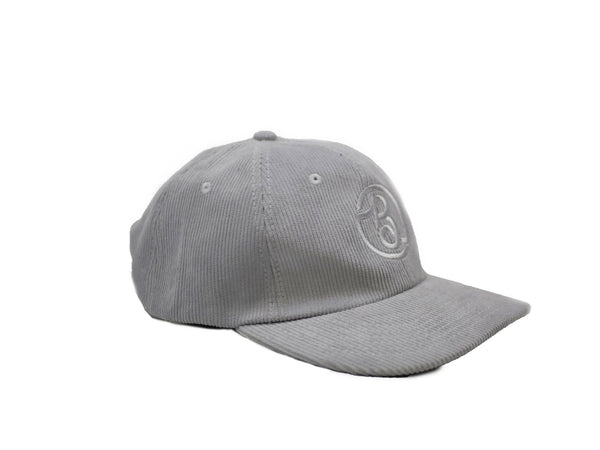 A grey baseball cap with a Bluetile Skateboards BLUETILE SUPPLY CO CORDUROY STRAP BACK GREY logo on it.