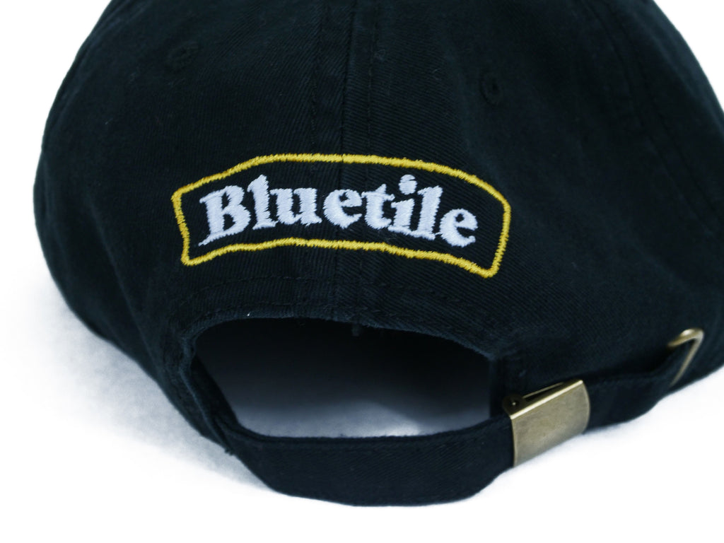 An unstructured hat in petro blue with the word Bluetile Skateboards on it.