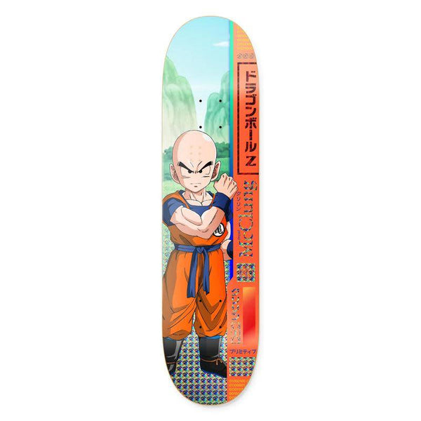 The PRE-ORDER!! PRIMITIVE X DRAGONBALL Z TRENT MCCLUNG KRILLIN skateboard deck by PRIMITIVE features Krillin with arms crossed and Japanese text on a scenic background. Available in various sizes.
