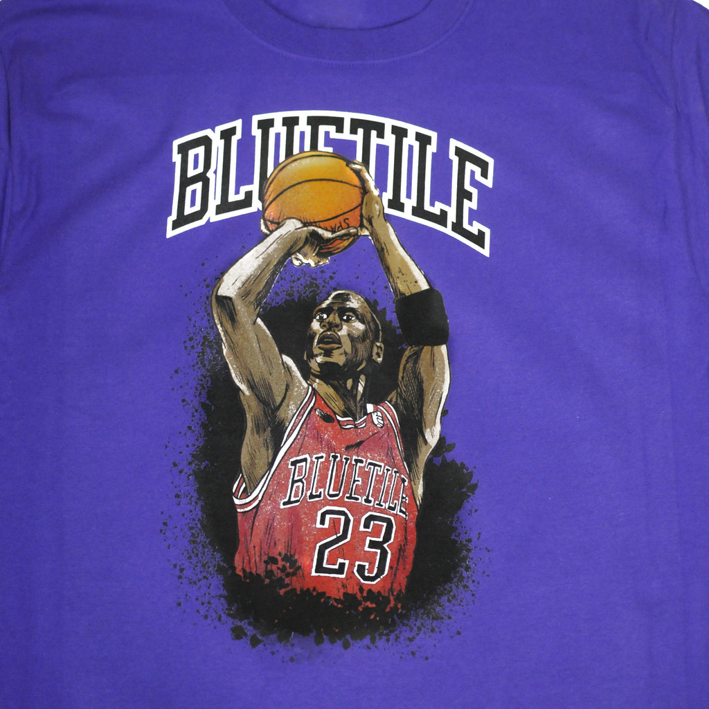 A BLUETILE JUMP SHOT T-SHIRT PURPLE with a basketball player on it from Bluetile Skateboards.