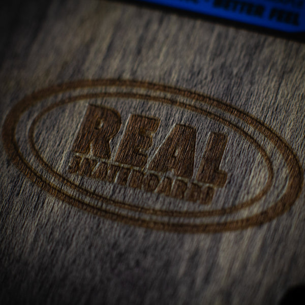 A woodburning of the Real Skateboards logo on the risers.