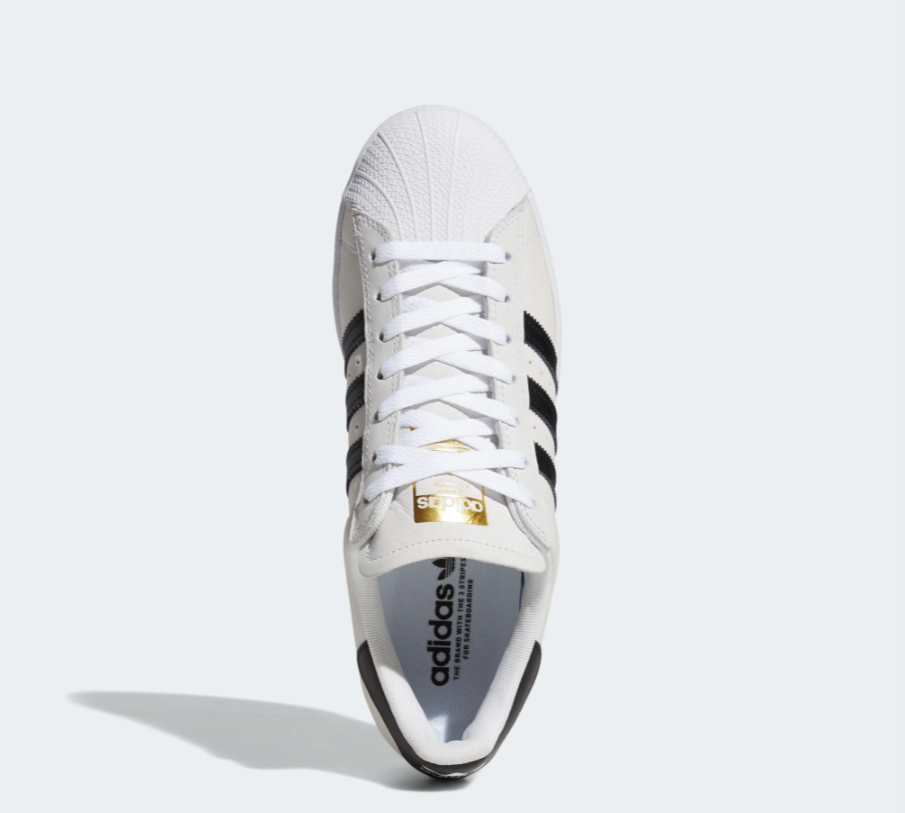 A pair of white and black ADIDAS SUPERSTAR ADV CLOUD WHITE / BLACK sneakers on a white background.