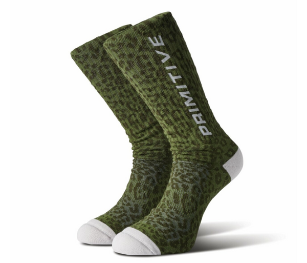 A pair of green camo-patterned "Primitive Prowler Socks" with the word "primitive" printed on them, displayed against a white background.