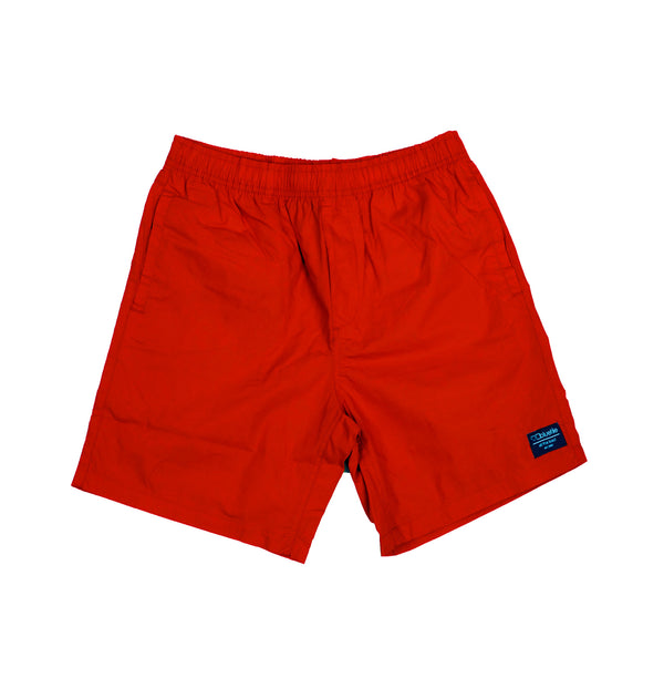 A pair of Bluetile Skateboards red beach shorts with a blue logo on the side.