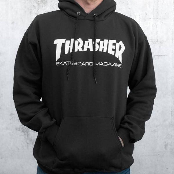 A person wearing a black THRASHER SKATE MAG LOGO HOODIE with their hand in the front pocket.