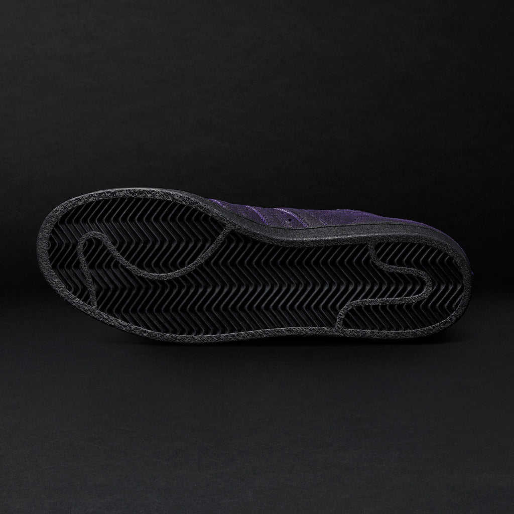 A close up of an ADIDAS KADER SYLLA PRO MODEL ADV CORE BLACK / DARK PURPLE shoe on a black background.