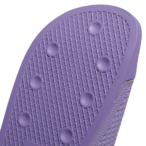 An Adidas Shmoofoil Slide Lilac/White with holes on the sole.