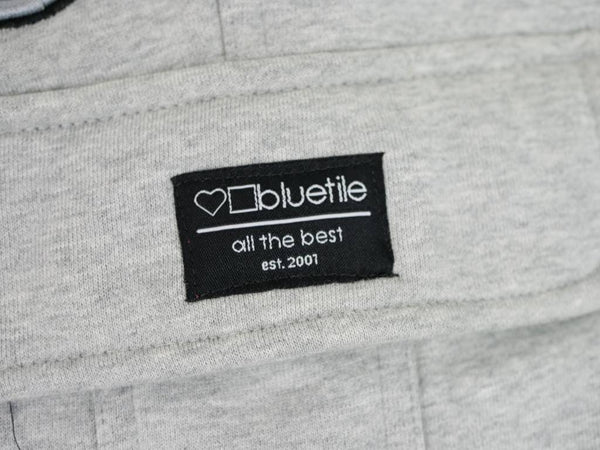A close up of a Bluetile Surplus Champion sweatshirt with a label on it.