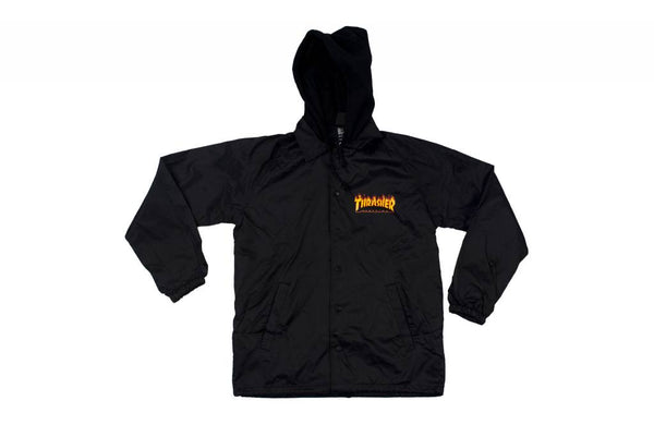 The THRASHER Magazine Flame Logo Hooded Coaches Jacket is black with elastic cuffs and features a small orange and yellow Thrasher logo on the left chest.