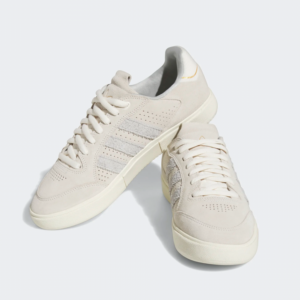 A pair of ADIDAS TYSHAWN LOW CHALK WHITE / GREY ONE / CREAM WHITE sneakers on a white surface.