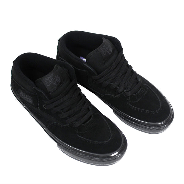 A pair of black VANS SKATE HALF CAB BLACK / BLACK sneakers on a white surface.