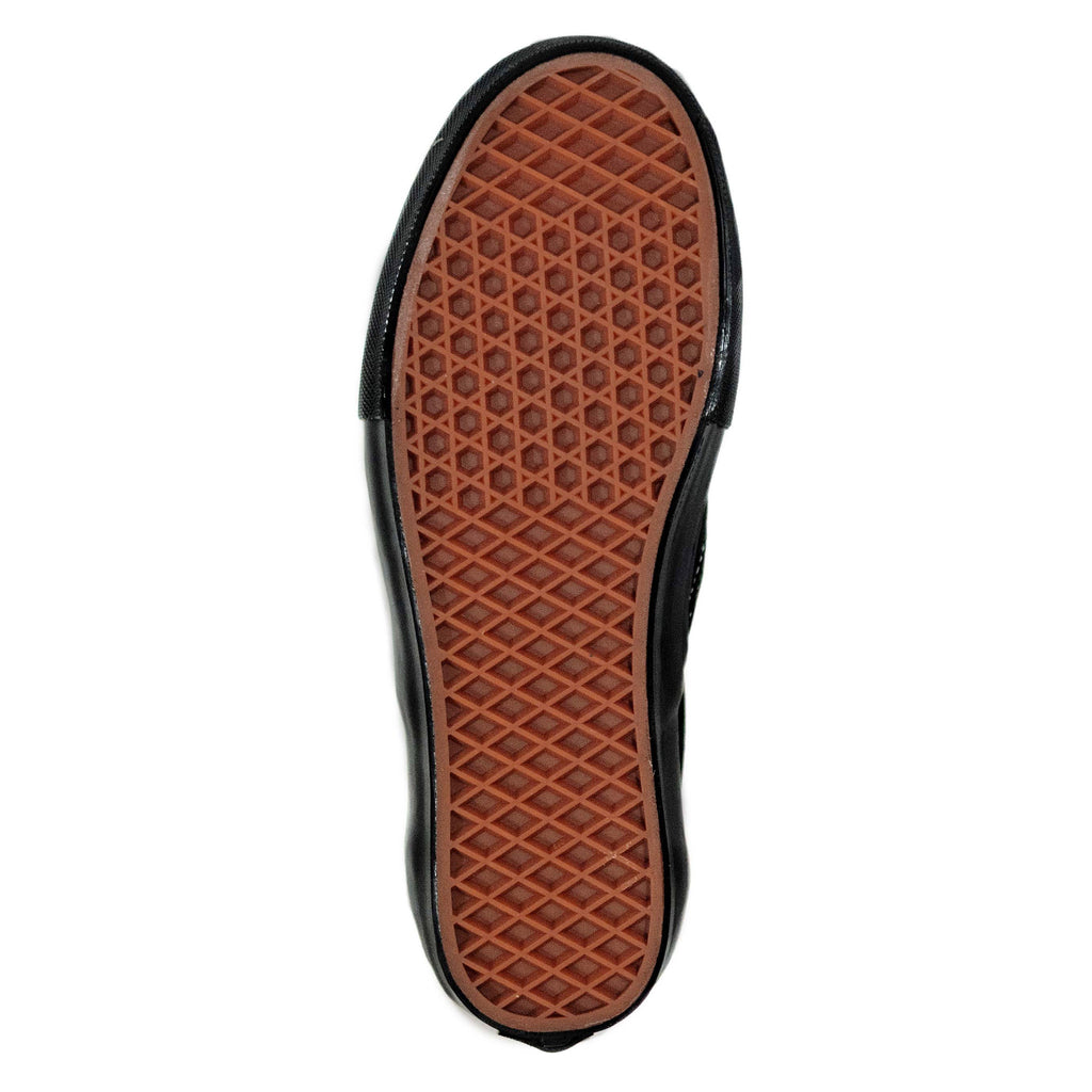 The rubber waffle sole of the black and black shoe.