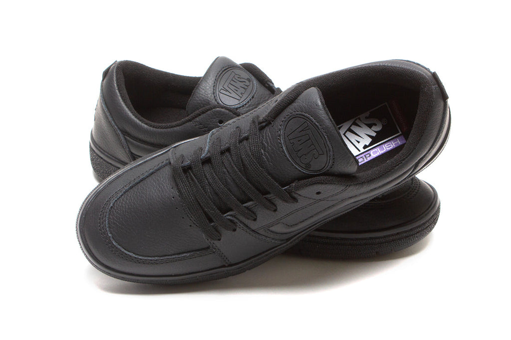 A pair of black VANS SKATE FAIRLANE BLACK LEATHER shoes sitting on top of each other.