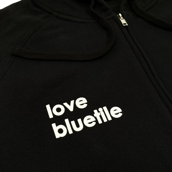 A BLUETILE LOVE BLUETILE ZIP UP BLACK hoodie from Bluetile Skateboards printed with the words "love bluetile.